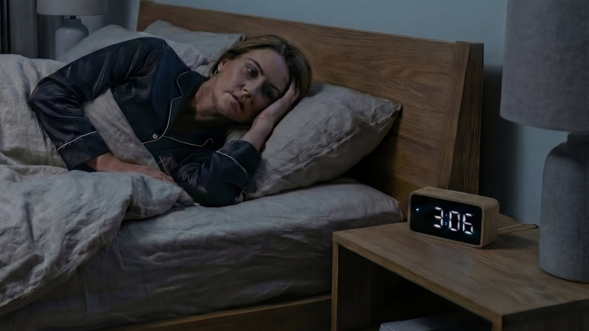 Woman lying awake in bed at 3am at night unable to fall back asleep
